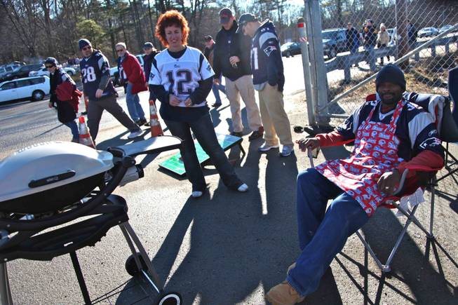 Donna and Calvin Coleman of Sandown, N.H., grill in the tailgating area outside Gillette Stadium on New Year's Day. The season-ticket holders say more friends would join them for tailgates if they could go to a casino while the Colemans attend the home football games.